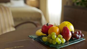 Una bandeja de fruta sobre una mesa con un folleto de hotel.