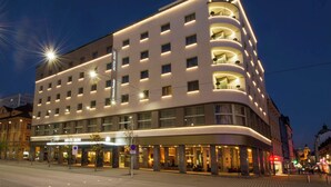 Un hôtel moderne à la façade incurvée, doté de nombreux balcons et d’une enseigne bien visible.