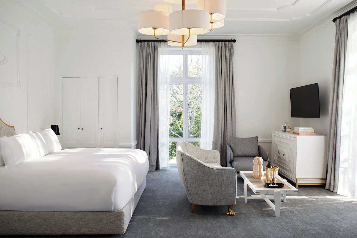 Ett hotellrum med en stor säng, en soffa, ett soffbord och en tv.