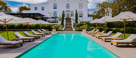 Una piscina al aire libre, tumbonas