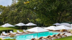 A pool area with lounge chairs and umbrellas. - The Alphen Boutique Hotel & Spa (Cape Town)