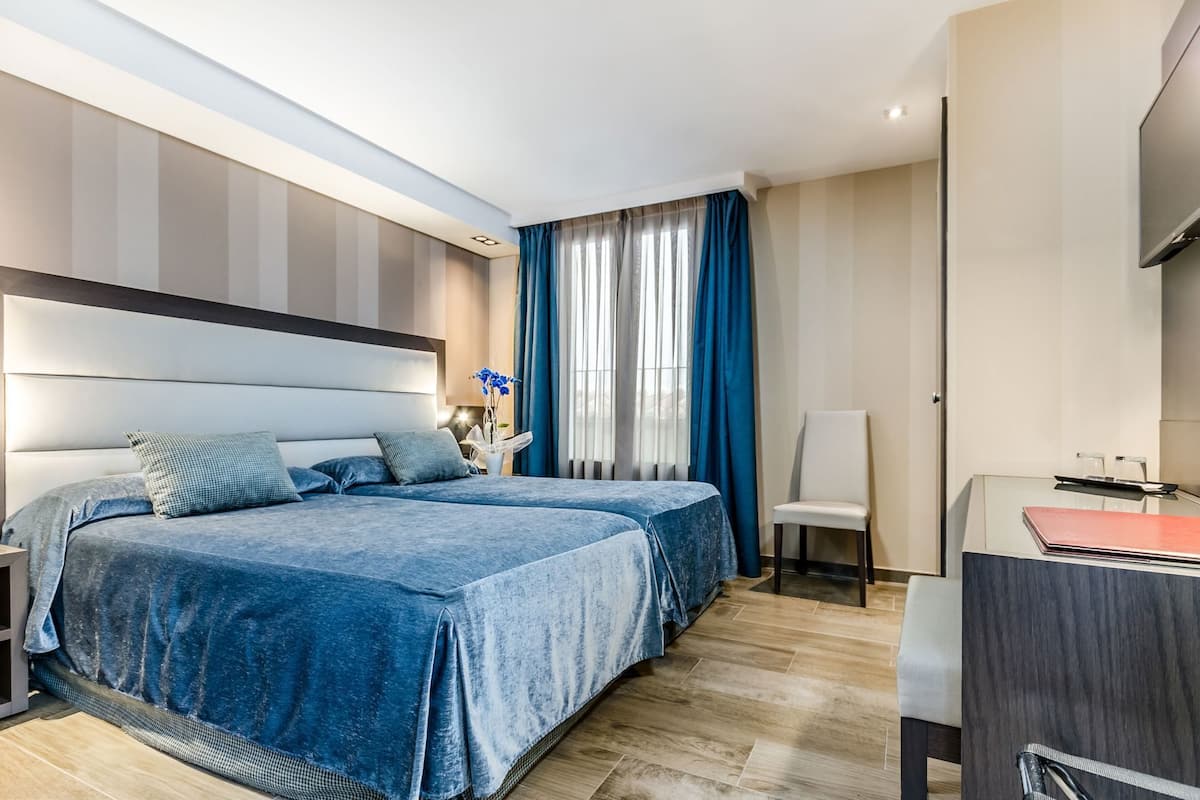 Una habitación de hotel moderna con una cama grande, un escritorio y una silla.