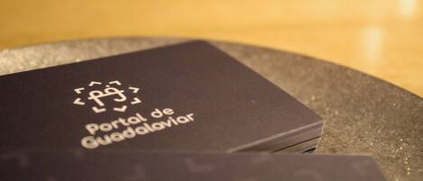 A stack of black business cards with the text 'Portal de Guadalarva' and a phone number.