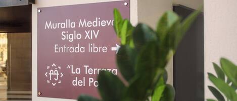 A sign indicating 'Muralla Medievale Siglo XIV' and 'Entrada libre' with a symbol for 'La Terrazza del Post.'