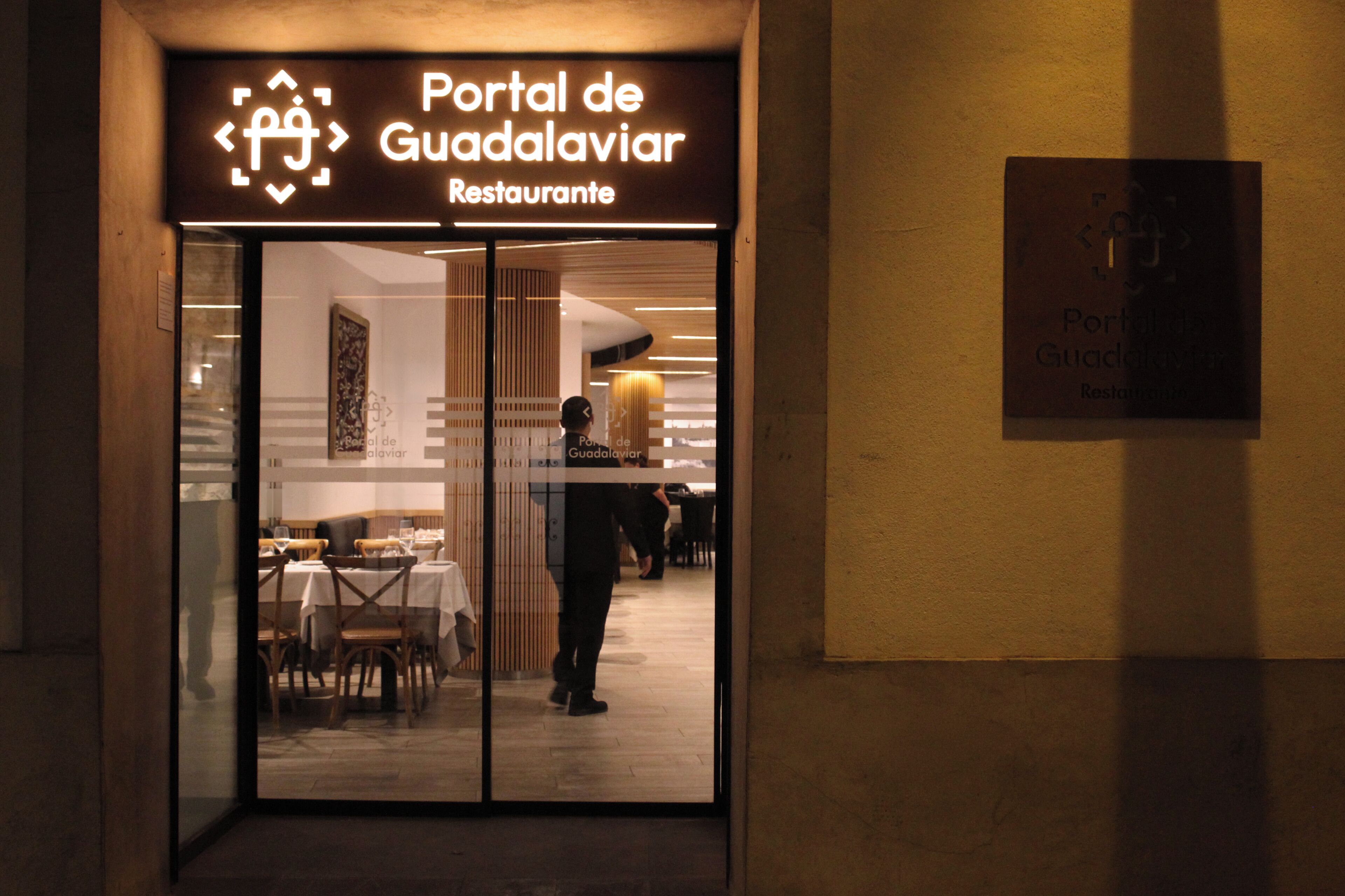Entrada a un restaurante con un letrero que dice 'Portal de Guadalaviar Restaurante'.