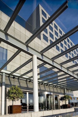 A modern building with a glass facade and a geometric metal framework.