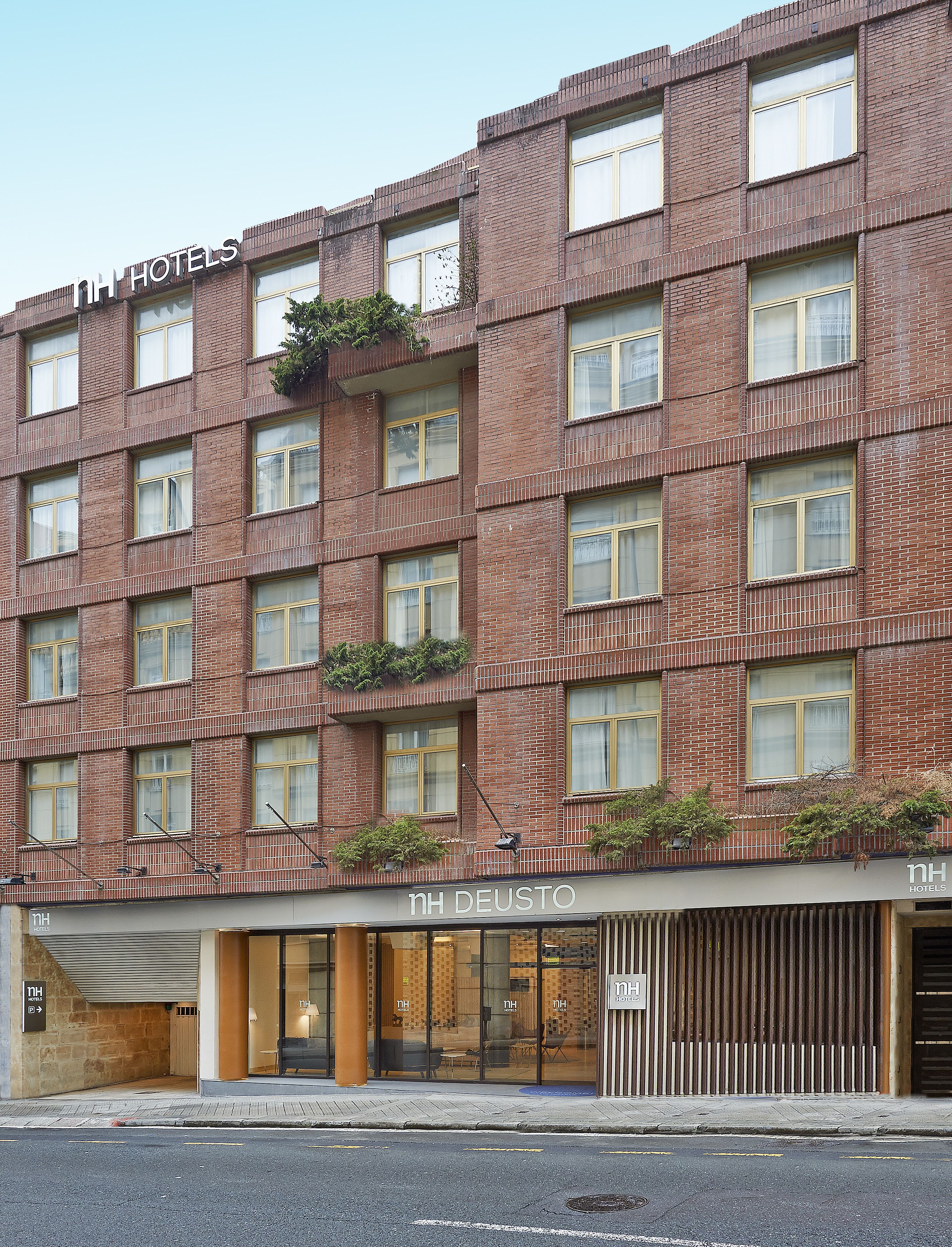 Un hotel de varios pisos con fachada de ladrillo, ventanas amplias y zonas de estar al aire libre.
