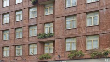 Un hotel de varios pisos con fachada de ladrillo, ventanas amplias y zonas de estar al aire libre.