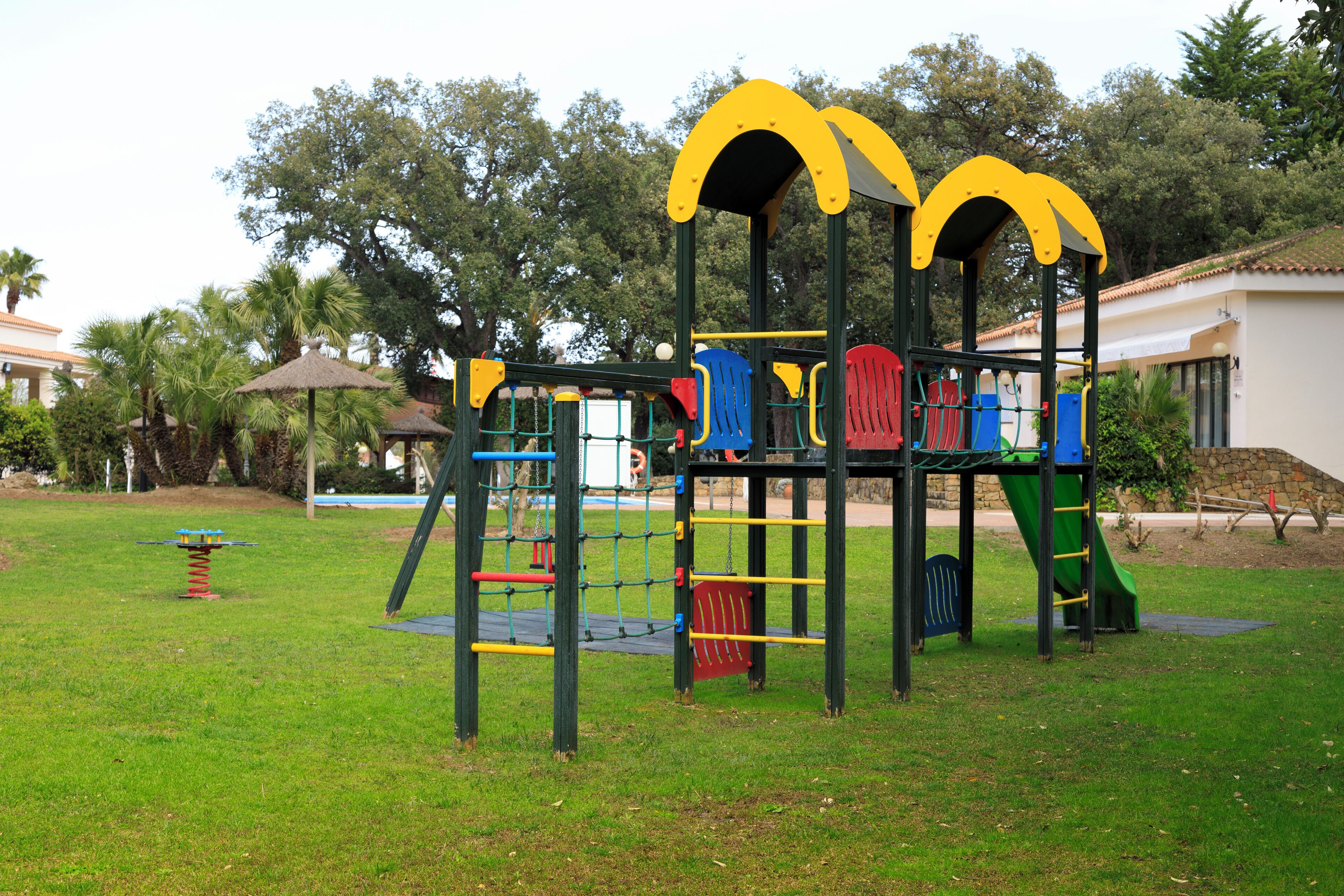 Un parque infantil con una estructura para escalar y toboganes.