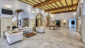 A spacious lobby with a high ceiling, marble flooring, and a seating area with sofas and a coffee table. - AZZ Guadacorte Campo de Gibraltar (Los Barrios)