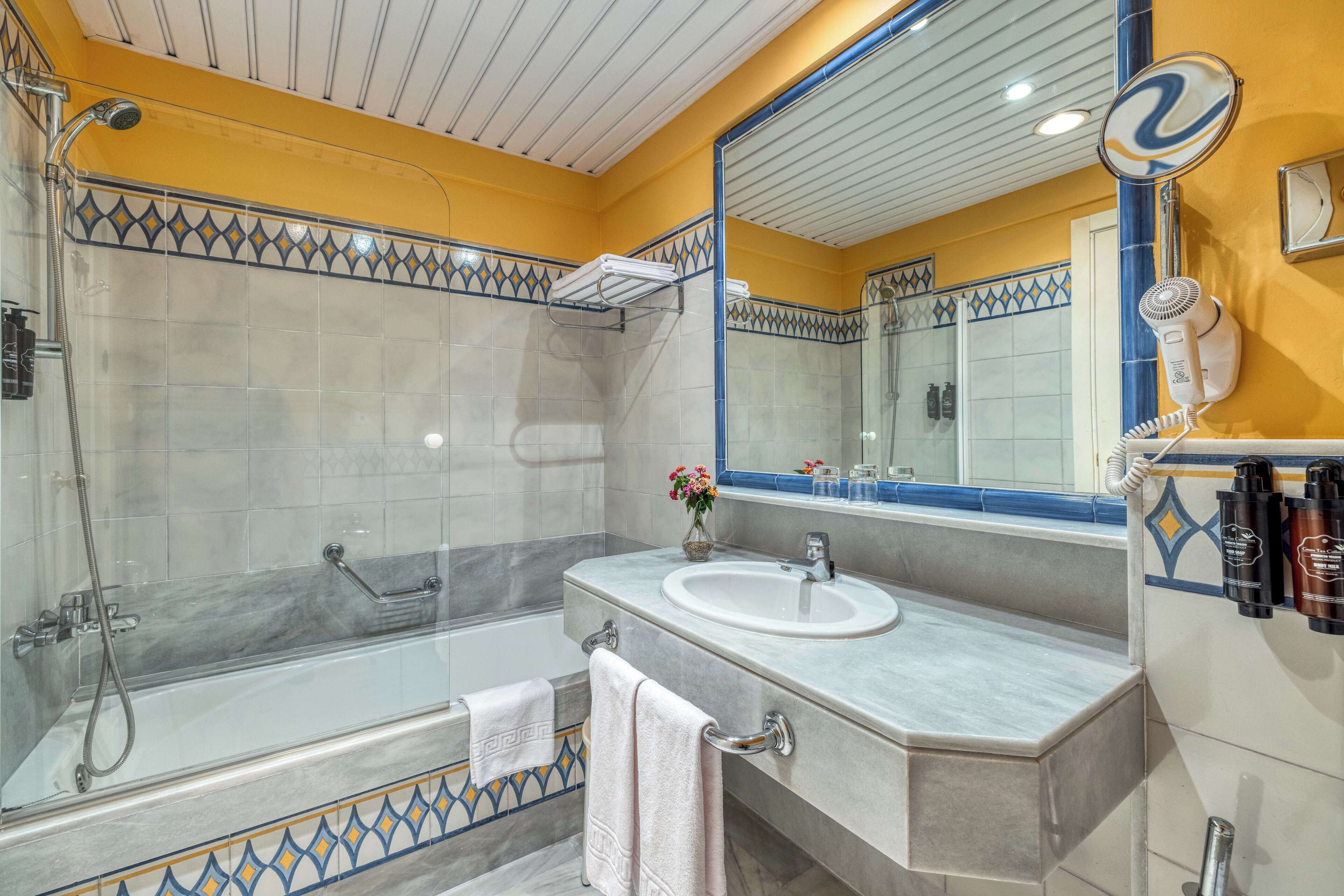 A bathroom with a shower, a sink, and a mirror.