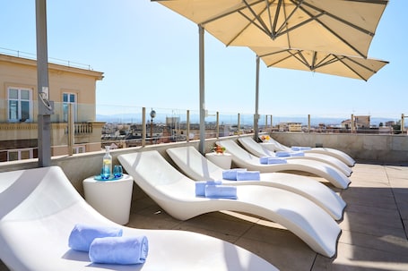 Una piscina al aire libre de temporada, sombrillas
