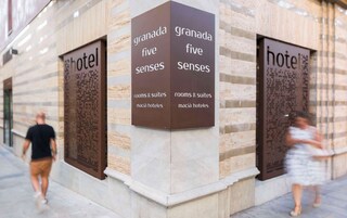 A hotel facade with signage for 'Granada Five Senses' and 'macía hotels'.