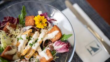 Vista clara de una ensalada con diversos ingredientes y una decoración floral.