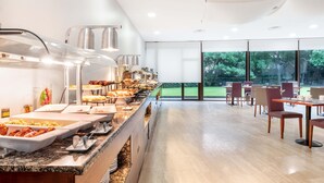Zona de buffet amb diverses opcions gastronòmiques i vista a l'exterior.