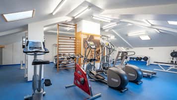 A gym with various exercise equipment, including treadmills, stationary bikes, and weight machines.
