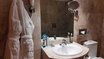 A bathroom with a white sink, a mirror, a towel rack, and a hairdryer.