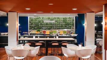 Zona de bar moderna amb una paret verda i un rètol que diu "FRUTERIA".