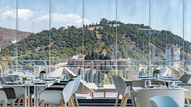 Ein Restaurant mit Terrasse und Blick auf eine Hügellandschaft.
