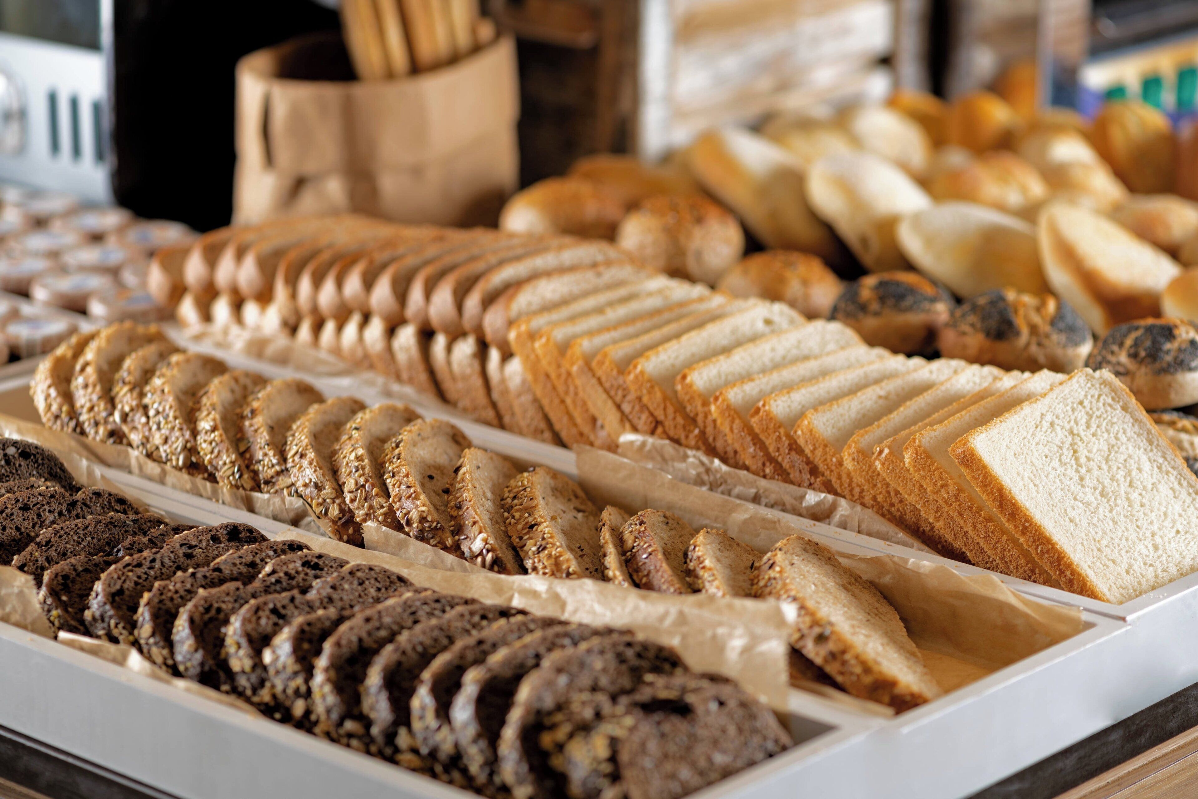 Una vitrina de panadería con diferentes tipos de pan y pasteles.