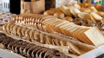 Una vitrina de panadería con diferentes tipos de pan y pasteles.