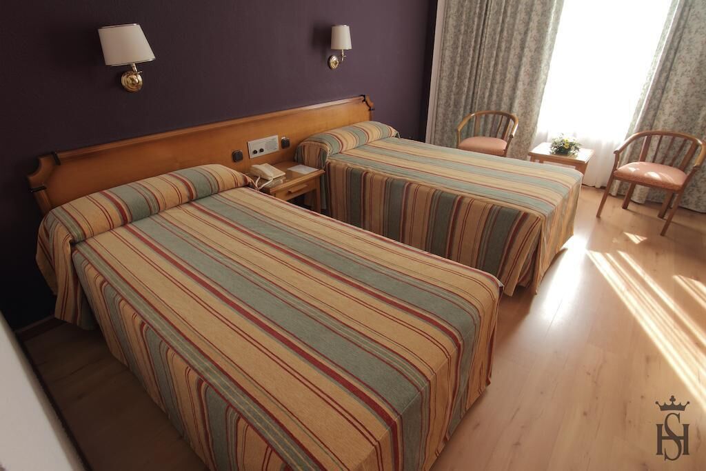 Minibar, escritorio, cortinas opacas y tabla de planchar con plancha