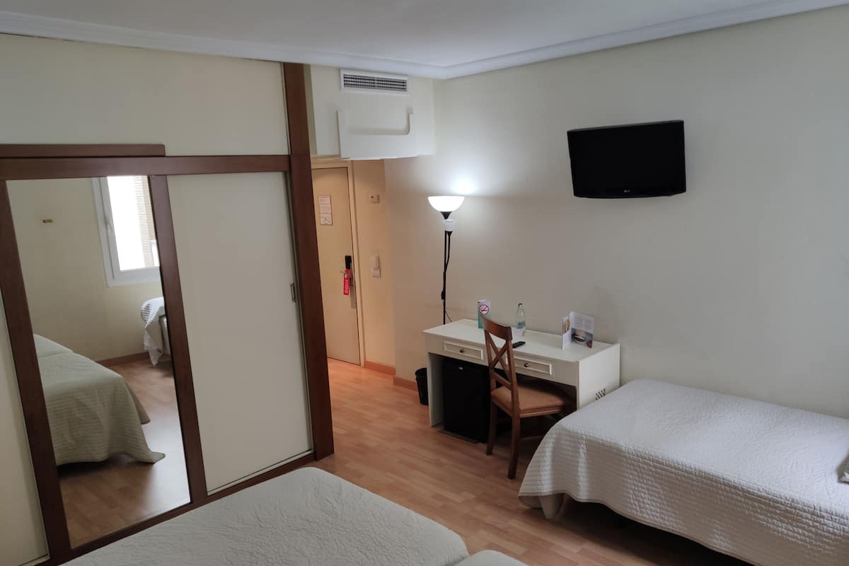 Family Triple Room | Minibar, in-room safe, desk, blackout drapes