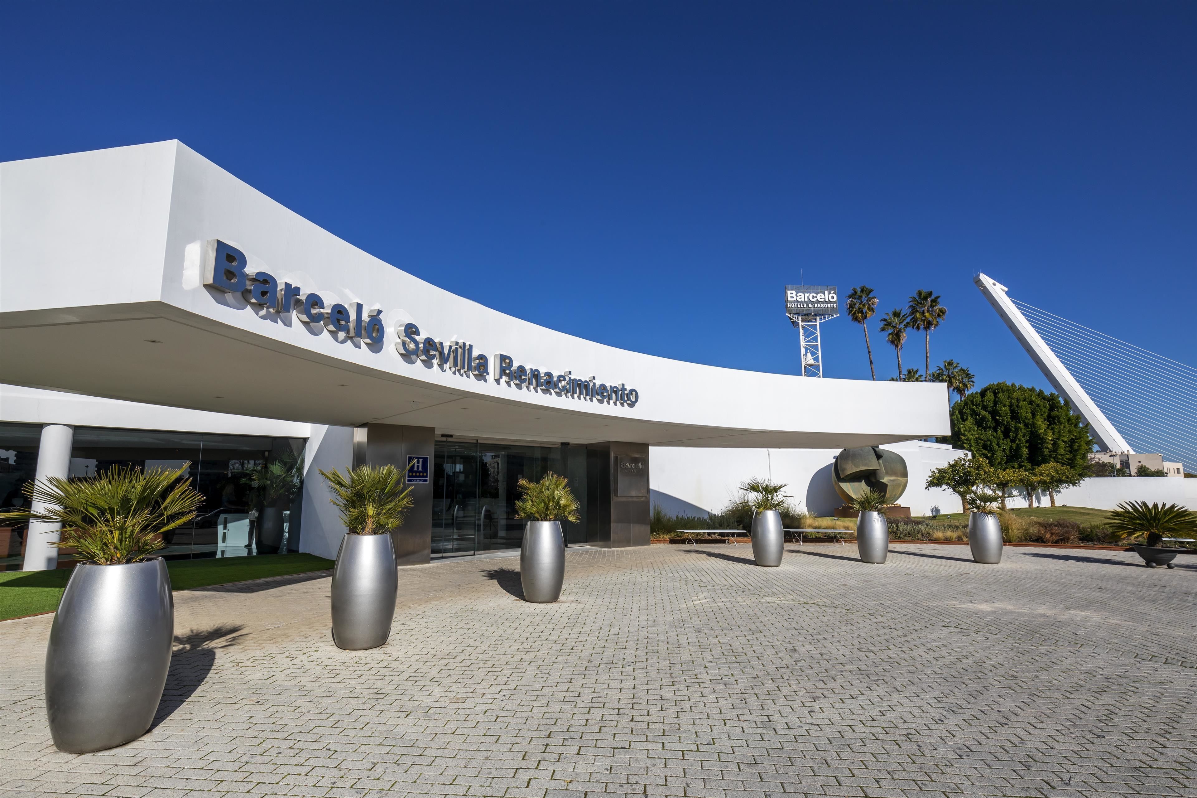 En moderne bygning med en buet facade, hvor navnet "Barceló Sevilla Renaixement" er tydeligt vist.