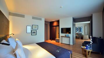 Ein Hotelzimmer mit einem Bett, einem Schreibtisch, einem Sessel und einem Fernseher.
