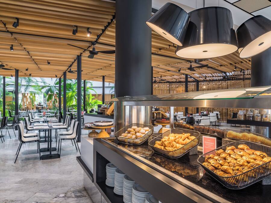 Un restaurante moderno con una zona de bufé que ofrece diversas opciones de pastelería.