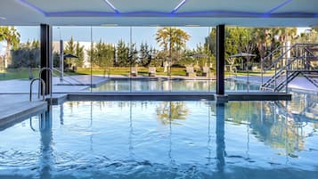 Una piscina techada, una piscina al aire libre de temporada, sombrillas