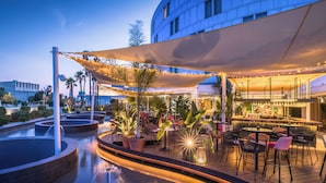 A rooftop bar with outdoor seating, a pool, and a bar area with a view of the city skyline. - Barceló Sevilla Renacimiento (Seville)
