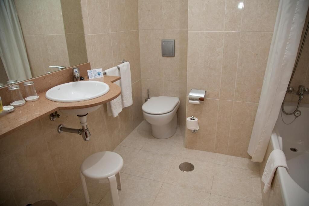 Un baño con lavabo, inodoro y ducha.