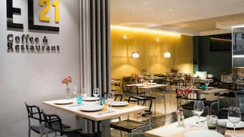 A modern coffee and restaurant interior with a clean, minimalist design, featuring a prominent EL21 sign on the wall.