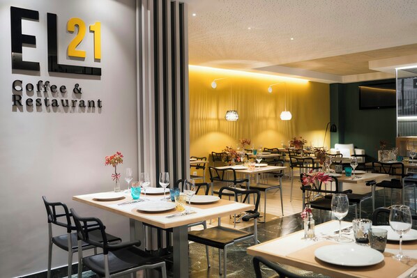 A modern coffee and restaurant interior with a clean, minimalist design, featuring a prominent EL21 sign on the wall. - Hotel Sercotel Tres Luces (Vigo)