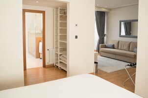 A modern living room with a beige sofa, a white rug, and a wooden floor.