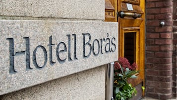 A stone sign with the name "Hotel Boras" mounted on a building.
