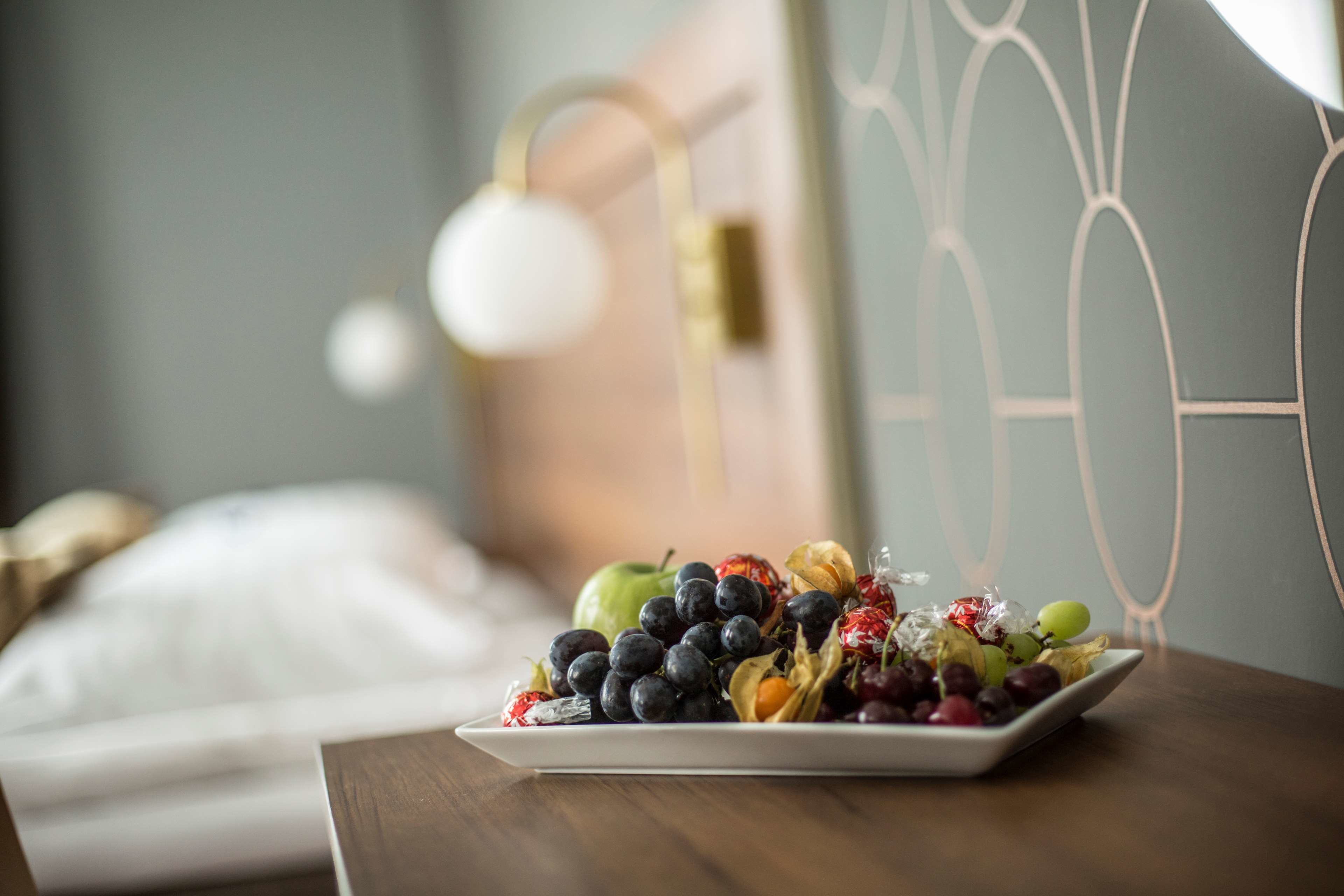 En tallerken med forskelligt frugt på et bord i et hotelværelse.