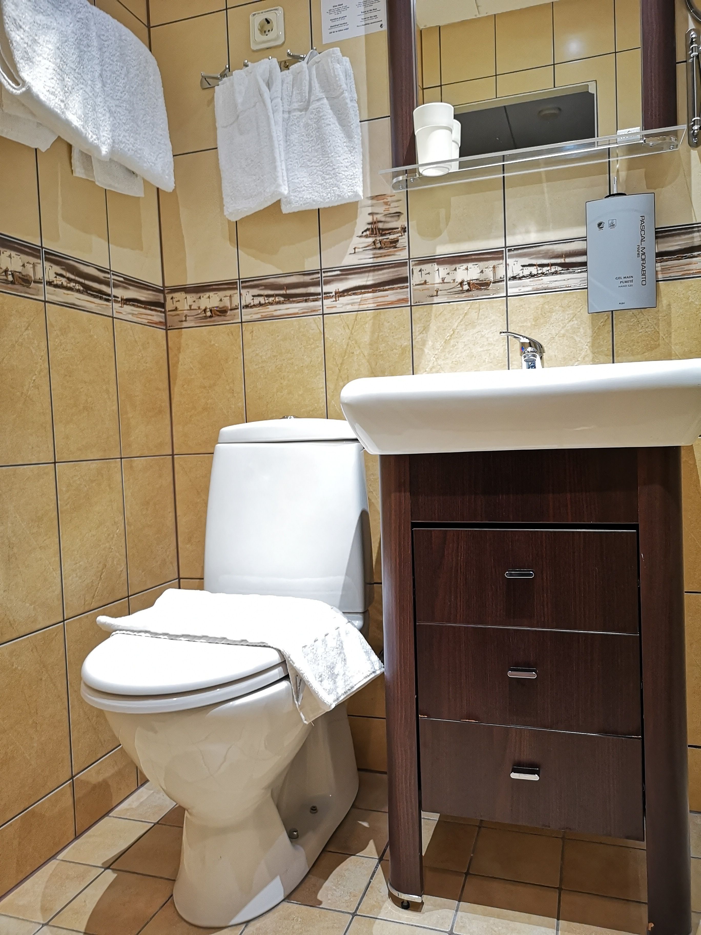 Un baño con inodoro, lavamanos y tocador.