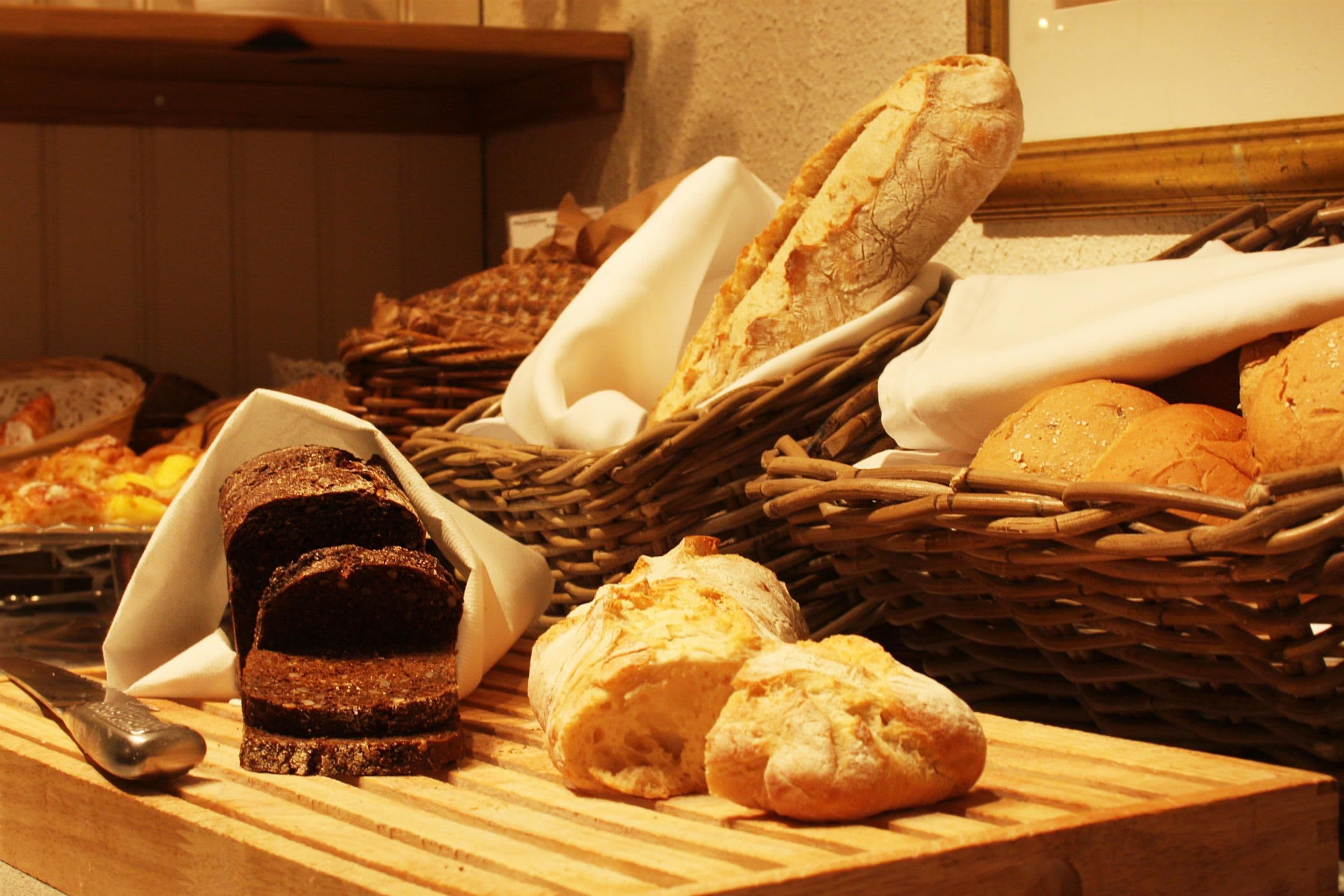 Verschiedene Brotsorten und Gebäck auf einem Holztisch.