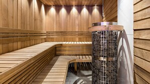 A sauna with wooden benches and a central stone pillar. - Best Western Plaza Hotel (Eskilstuna)