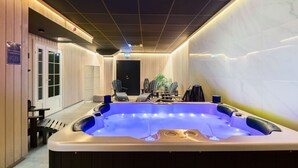 A spa area with a hot tub, seating, and a door leading to another room. - Best Western Plaza Hotel (Eskilstuna)