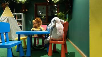 Children can play and read in this inviting space with a table, chairs, and a bookshelf.