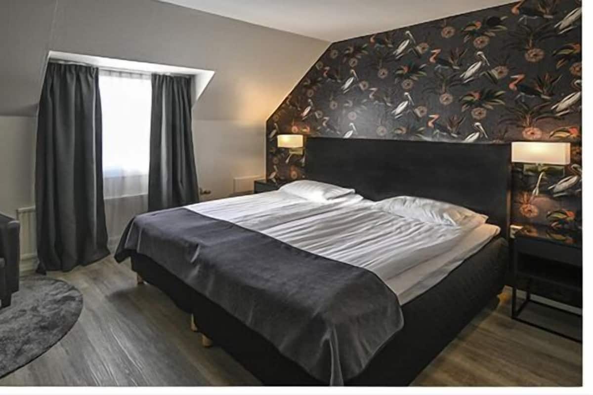 Ropa de cama hipoalergénica y caja de seguridad en la habitación