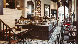 L'intérieur d'un restaurant, avec un bar central, des tables et des chaises.
