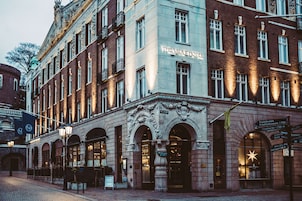 Un edificio histórico con el letrero "The Vault Hotel", que presenta una arquitectura ornamentada y una fachada bien iluminada.
