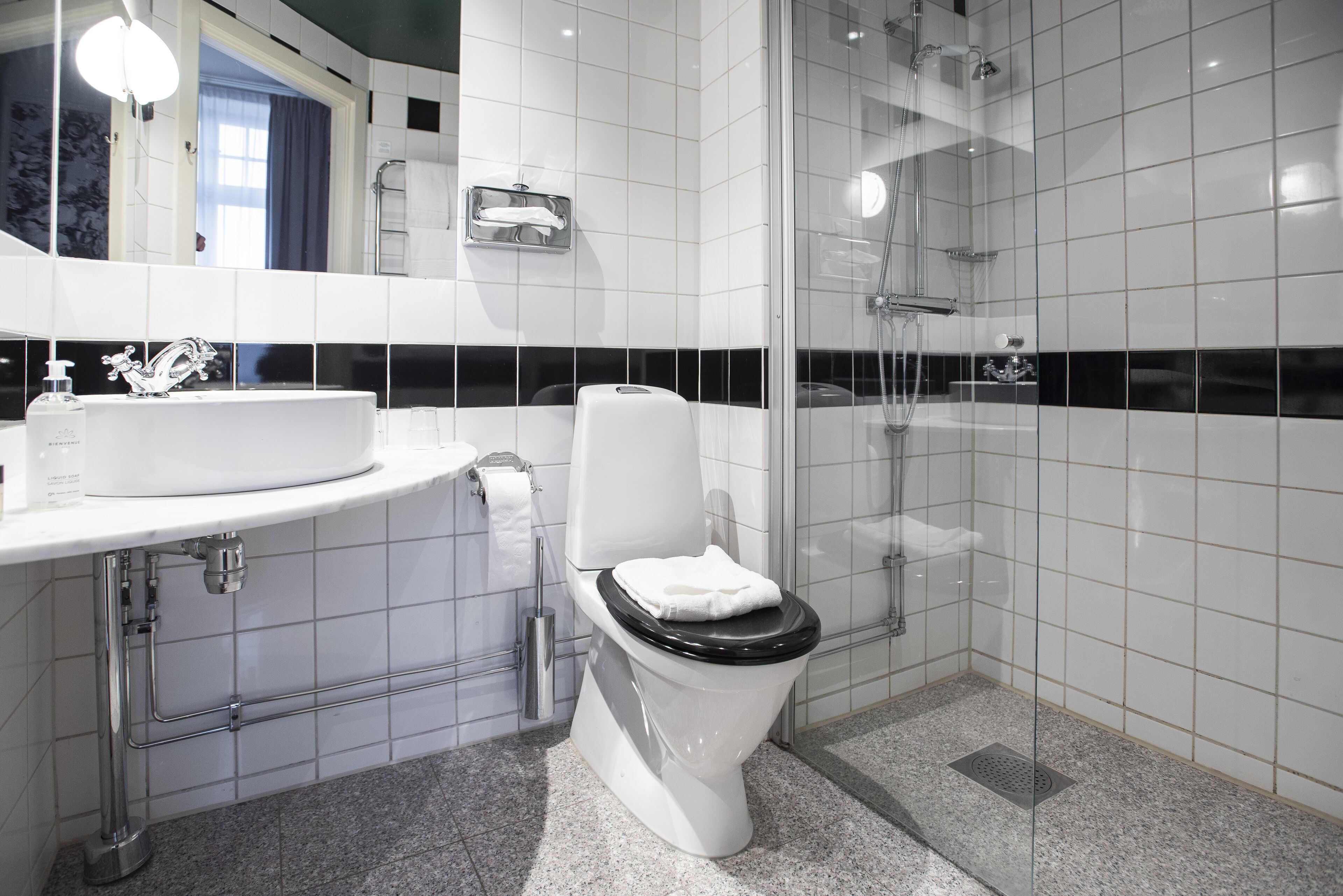 Un baño moderno con inodoro, lavamanos y ducha.