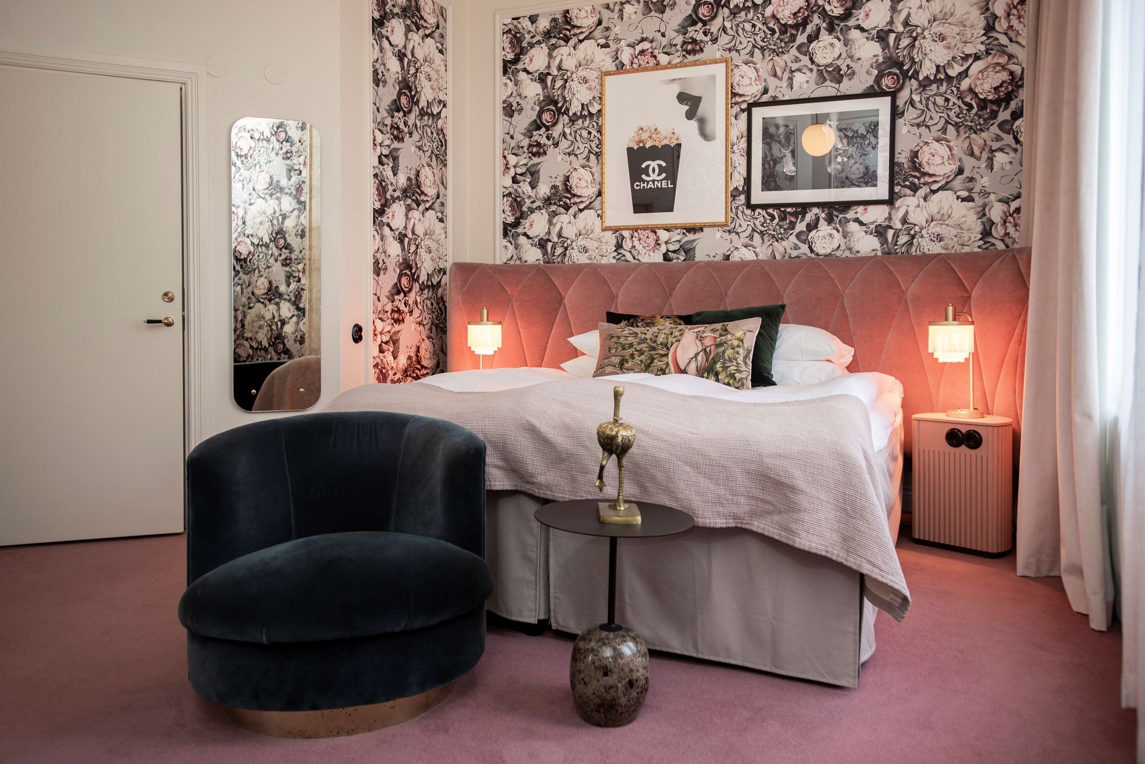 Ein Schlafzimmer mit einem Bett, zwei Nachttischlampen, einem runden Tisch, einem Stuhl und einem Spiegel.