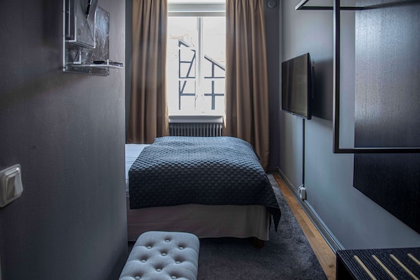 A bedroom with a bed, a television, a window with curtains, and a radiator. - V Hotel Helsingborg, BW Premier Collection (Helsingborg)