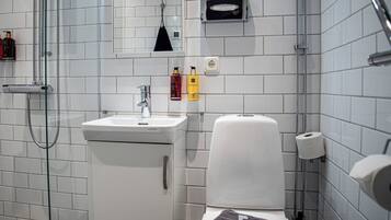 Een moderne badkamer met een douchecabine van glas, een wit wastafelmeubel en een toilet.